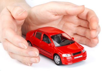 Red car in hands on a white background. Concept of safe driving